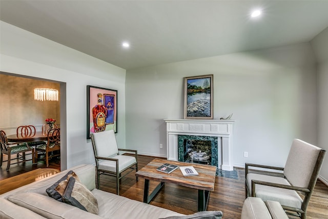 living room with dark hardwood / wood-style floors, lofted ceiling, and a high end fireplace