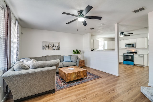 living room featuring light hardwood / wood-style floors and ceiling fan