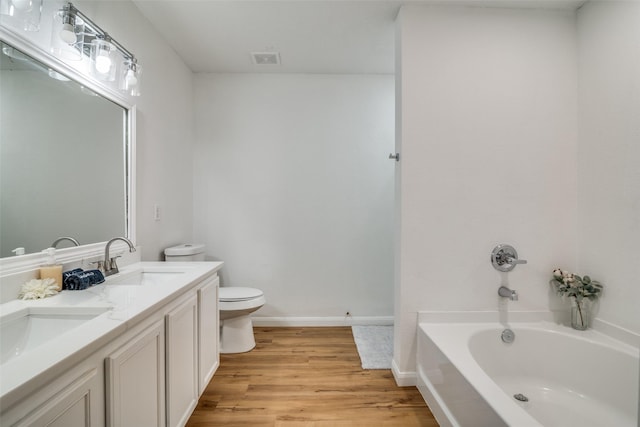 bathroom featuring toilet, a bathtub, vanity, and hardwood / wood-style flooring