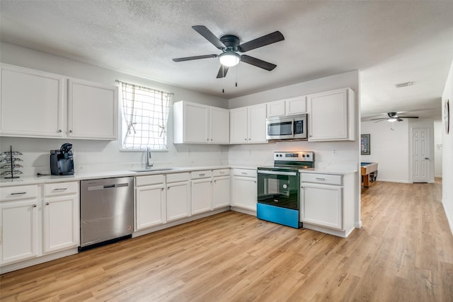 kitchen with appliances with stainless steel finishes, sink, light hardwood / wood-style flooring, white cabinetry, and pool table