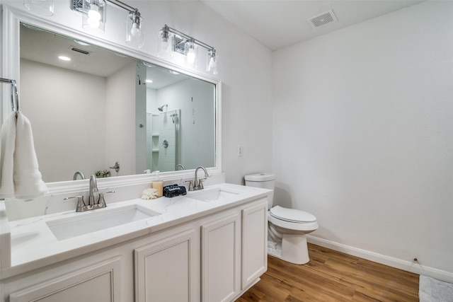 bathroom featuring toilet, a shower with door, vanity, and hardwood / wood-style flooring