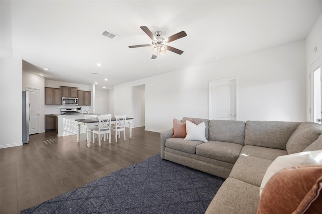 living area with dark wood-style flooring, recessed lighting, visible vents, a ceiling fan, and baseboards