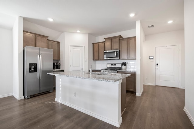 kitchen featuring dark wood-style flooring, a sink, visible vents, appliances with stainless steel finishes, and tasteful backsplash