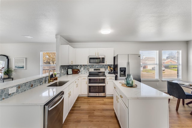 kitchen featuring tasteful backsplash, stainless steel appliances, sink, and white cabinets