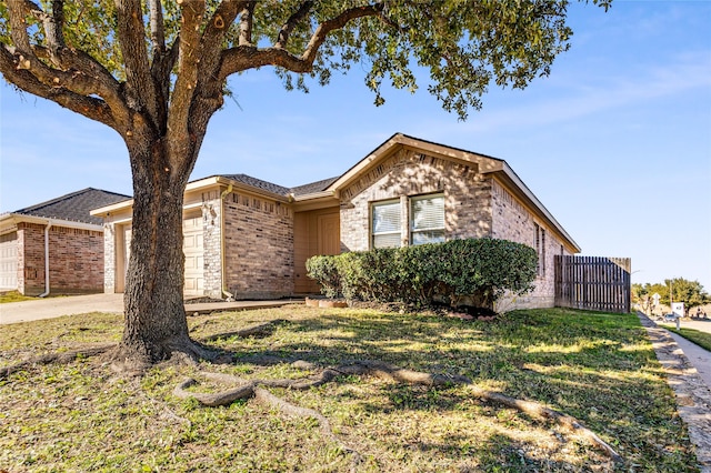 ranch-style home featuring concrete driveway, brick siding, a front lawn, and an attached garage