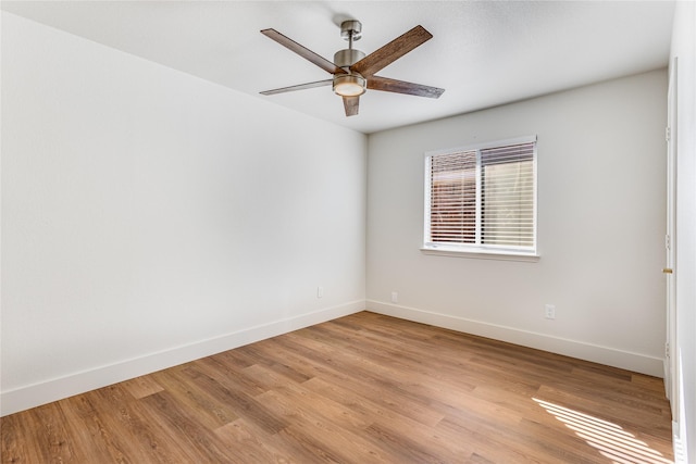 spare room featuring ceiling fan, baseboards, and light wood-style flooring