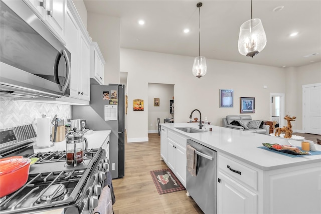 kitchen featuring a kitchen island with sink, sink, white cabinetry, and appliances with stainless steel finishes