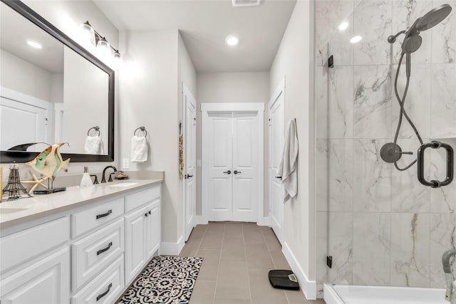 bathroom with tile patterned floors, vanity, and a shower with door