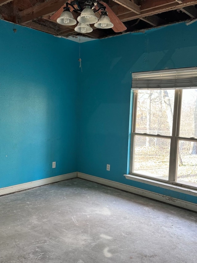 empty room with ceiling fan and concrete flooring