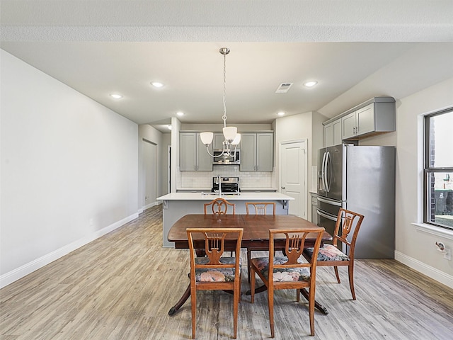 dining space featuring a chandelier and light wood-type flooring