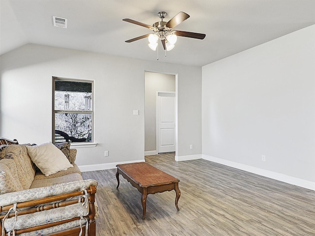 living room with wood-type flooring, vaulted ceiling, and ceiling fan