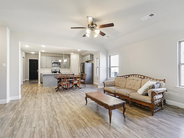 living room with vaulted ceiling, light hardwood / wood-style flooring, a wealth of natural light, and ceiling fan