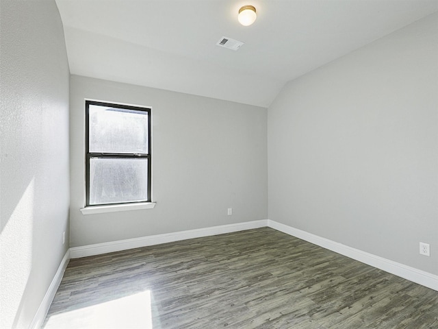 empty room with lofted ceiling and dark wood-type flooring