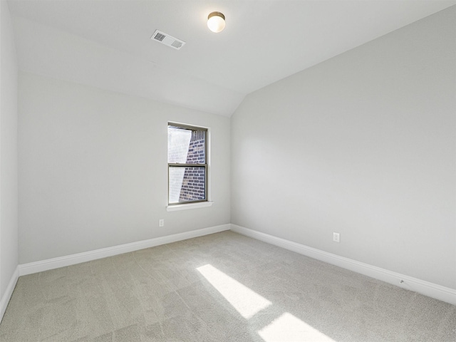 carpeted spare room featuring lofted ceiling