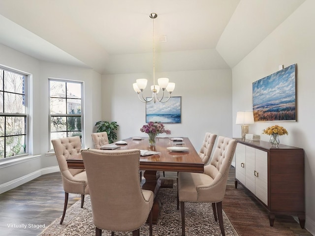 dining area featuring lofted ceiling, dark wood-type flooring, and a notable chandelier