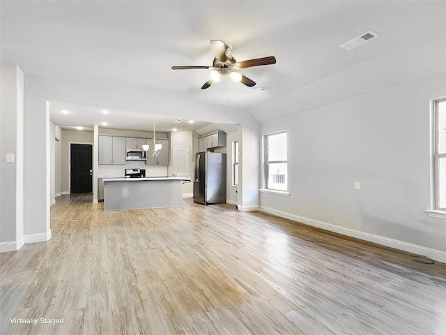 unfurnished living room featuring ceiling fan, light hardwood / wood-style floors, and vaulted ceiling