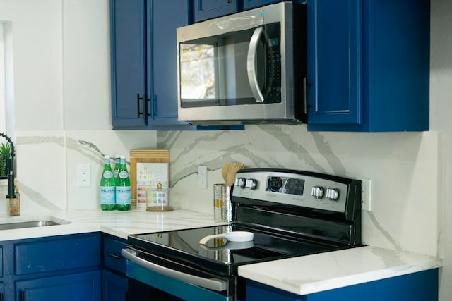 kitchen featuring backsplash, electric range, sink, and blue cabinets