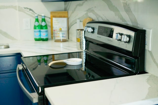 kitchen with stainless steel electric range and light stone countertops