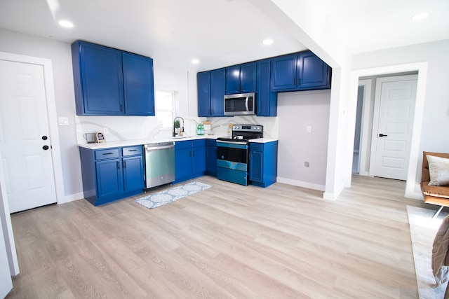 kitchen featuring light wood-type flooring, stainless steel appliances, and blue cabinets