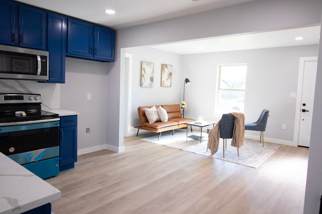 kitchen with light stone countertops, stainless steel appliances, light hardwood / wood-style floors, and blue cabinets