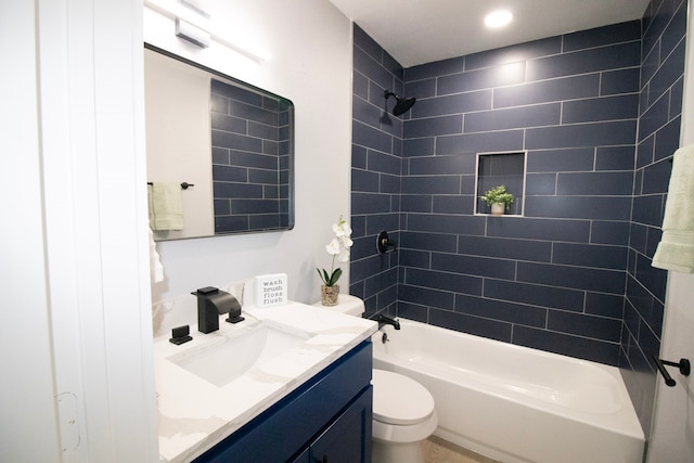 full bathroom with vanity, tiled shower / bath combo, and toilet