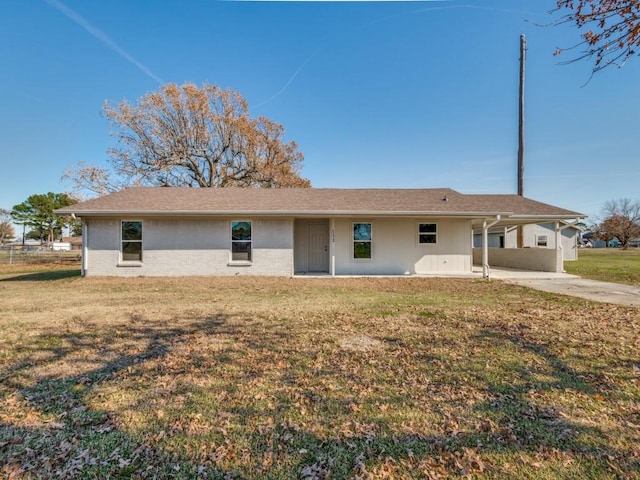 rear view of house with a lawn and a carport