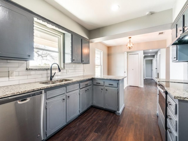 kitchen with gray cabinetry, sink, stainless steel appliances, tasteful backsplash, and dark hardwood / wood-style floors