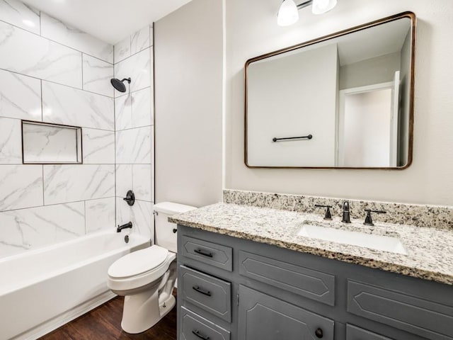 full bathroom with toilet, vanity, wood-type flooring, and tiled shower / bath