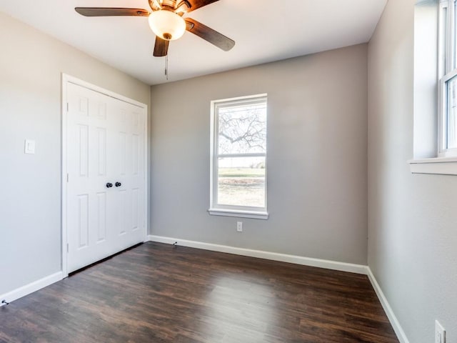 unfurnished bedroom with a closet, dark hardwood / wood-style floors, and ceiling fan