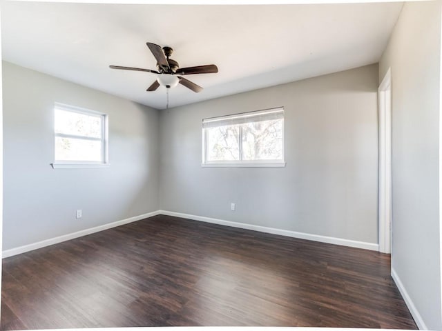 spare room with dark hardwood / wood-style floors, ceiling fan, and a wealth of natural light