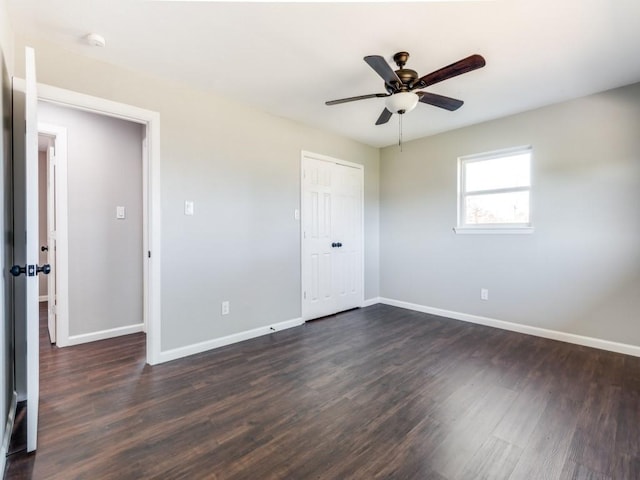 unfurnished bedroom featuring ceiling fan, dark hardwood / wood-style flooring, and a closet