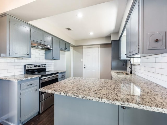 kitchen featuring stainless steel range with electric stovetop, sink, dark hardwood / wood-style floors, decorative backsplash, and kitchen peninsula