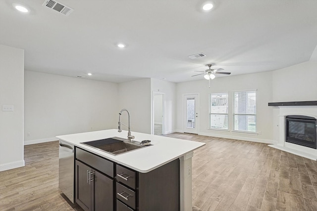 kitchen featuring stainless steel dishwasher, ceiling fan, light hardwood / wood-style floors, and sink