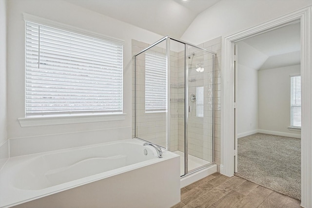 bathroom featuring independent shower and bath and vaulted ceiling