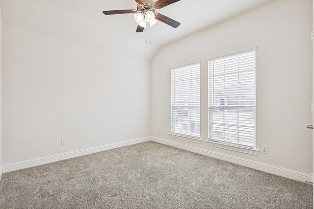 carpeted empty room with vaulted ceiling and ceiling fan