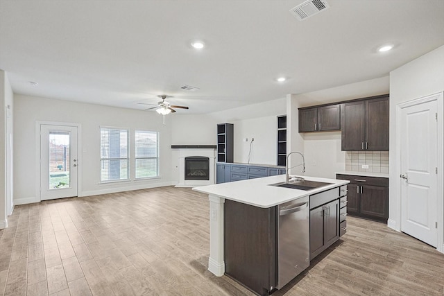 kitchen featuring dishwasher, dark brown cabinets, a kitchen island with sink, and ceiling fan