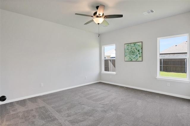 empty room featuring carpet, ceiling fan, and a healthy amount of sunlight