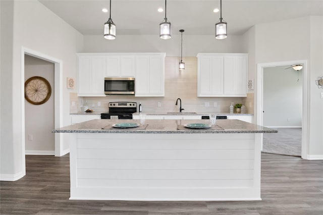 kitchen featuring a center island with sink, white cabinets, and appliances with stainless steel finishes