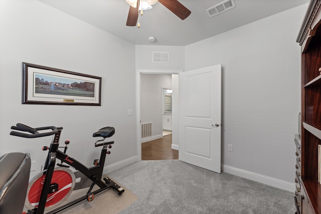 workout room featuring dark carpet and ceiling fan