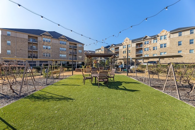 view of community featuring a yard, a playground, and a pergola