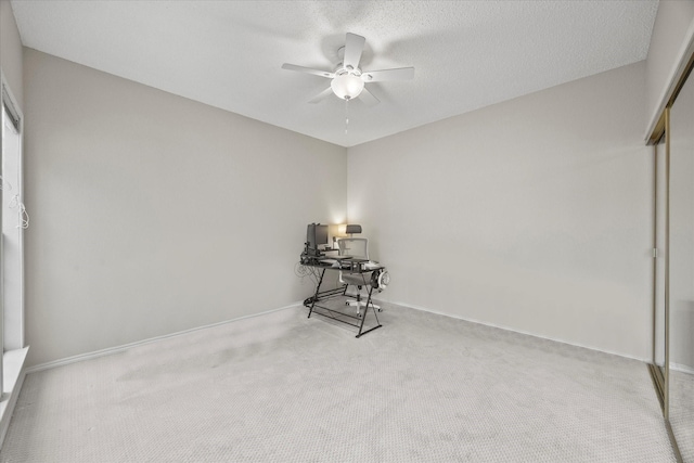 carpeted spare room featuring ceiling fan and a textured ceiling