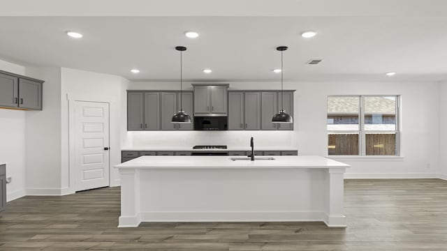 kitchen with gray cabinets, light countertops, a sink, and visible vents