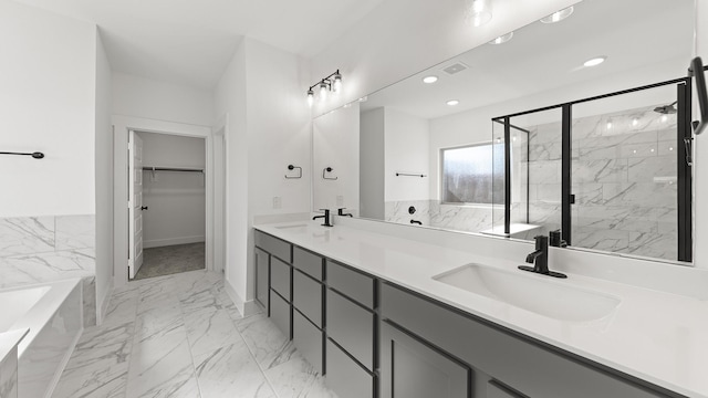 bathroom featuring marble finish floor, a spacious closet, a sink, and visible vents