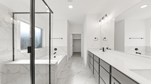 bathroom with recessed lighting, a sink, marble finish floor, a spacious closet, and a bath