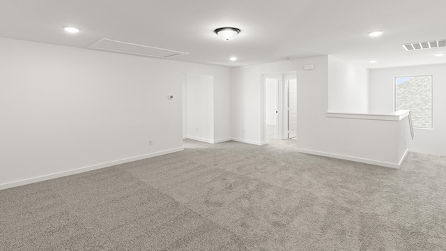 empty room with carpet floors, recessed lighting, visible vents, and baseboards