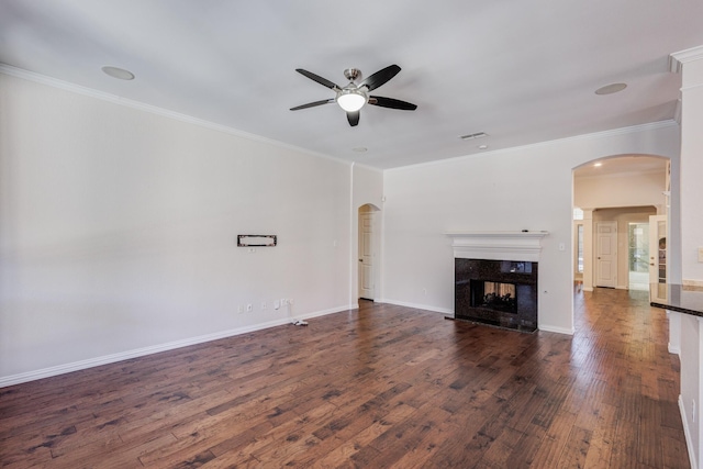 unfurnished living room featuring ceiling fan, crown molding, dark wood-type flooring, and a high end fireplace