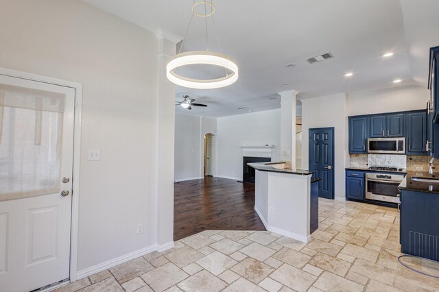 kitchen featuring pendant lighting, backsplash, ceiling fan, blue cabinetry, and stainless steel appliances