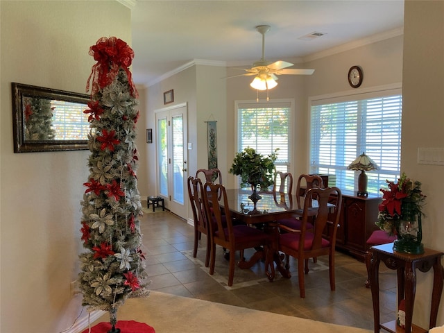 dining area with tile patterned flooring, crown molding, and ceiling fan