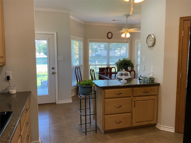 kitchen featuring light tile patterned floors, sink, crown molding, kitchen peninsula, and dark stone counters