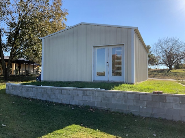 view of side of property featuring french doors and a lawn